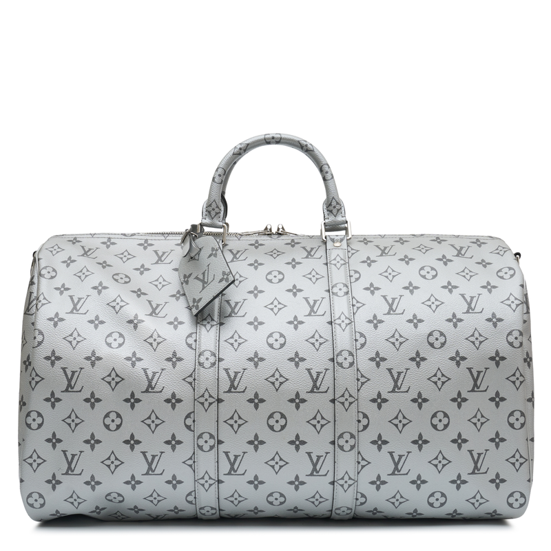 Louis Vuitton Metallic Monogram Keepall Bandoulière 50 in silver Monogram canvas with rolled top handles, silver-tone hardware, top zip closure and matching luggage tag.