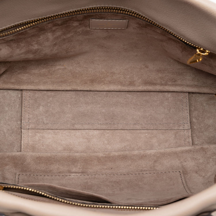 Louis Vuitton Veau Cachemire Tote PM handbag in soft leather with sleek design and subtle branding, displayed against a neutral background.