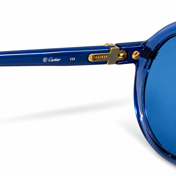 Close-up of blue Cartier sunglasses showing the elegant frame and brand logo, showcasing luxury eyewear design.