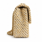 Chanel medium gold tweed shoulder bag with a single flap and chain strap, showcasing elegant craftsmanship and textured fabric.