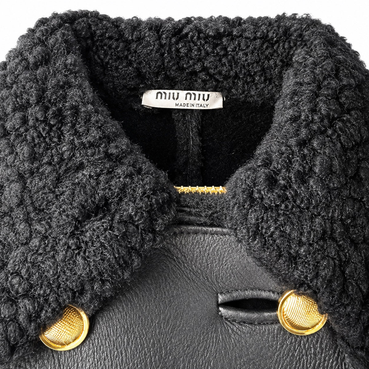 Black leather coat with shearling trim from Miu Miu, featuring a collar and stylish, warm design.