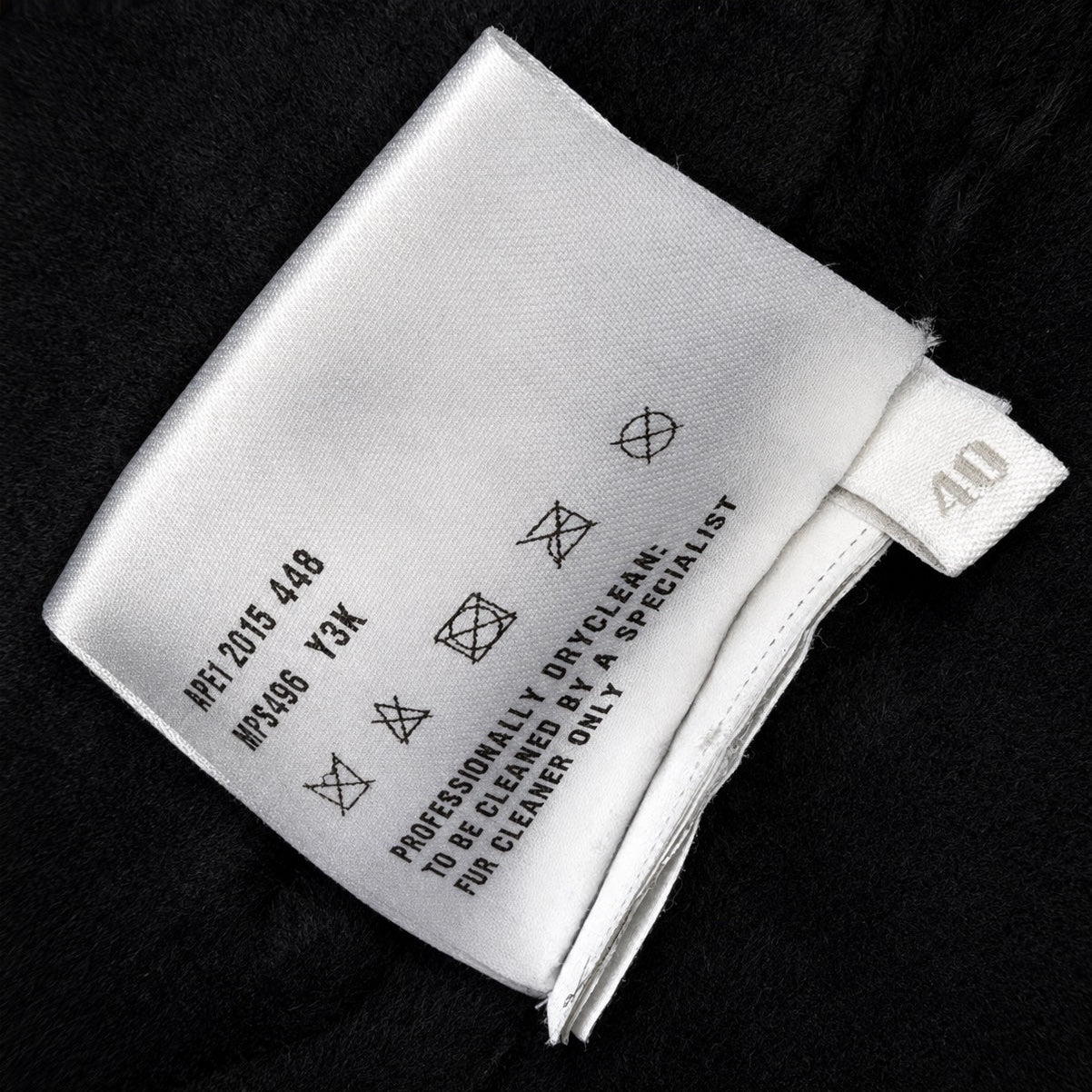 Black leather Miu Miu coat with shearling trim, featuring a classic collar and stylish silhouette.