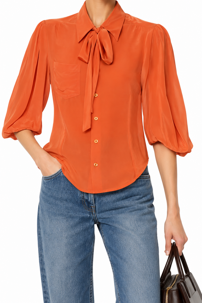 Prada coral silk shirt, a stylish top featuring smooth silk fabric and a classic collar, displayed on a hanger.