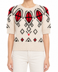 Prada cream short-sleeve intarsia knit jumper, model showing front view with detailed knit pattern and crew neckline.