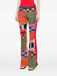 Pre-owned PUCCI pleated printed jersey flared trousers shown on a model, featuring a vibrant pattern and wide-leg design.