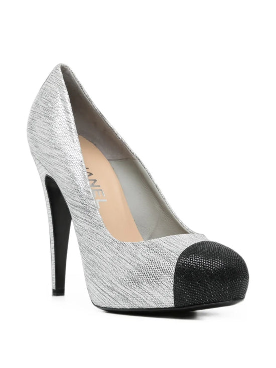 Silver Chanel pumps shoes with pointed toes and sleek design, shown from a side view.