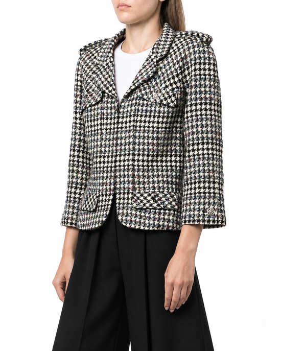 Chanel 2006 houndstooth zip-up jacket featuring a classic pattern, tailored fit, and stylish collar, displayed on a hanger.