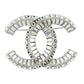 Elegant Chanel crystal brooch pin with intricate design, featuring sparkling crystals on a polished metal setting.