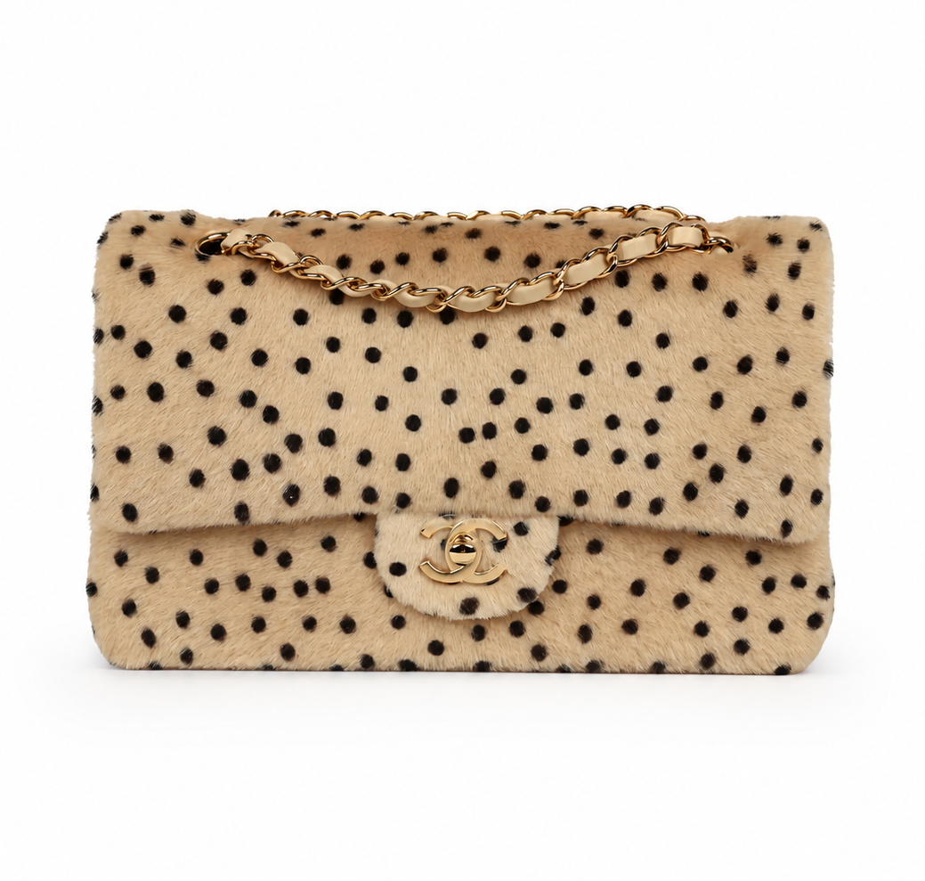 A beige faux fur double flap Chanel cheetah print  handbag with  featuring a gold-tone chain strap and a gold interlocking CC logo on the front flap, set against a plain white background.