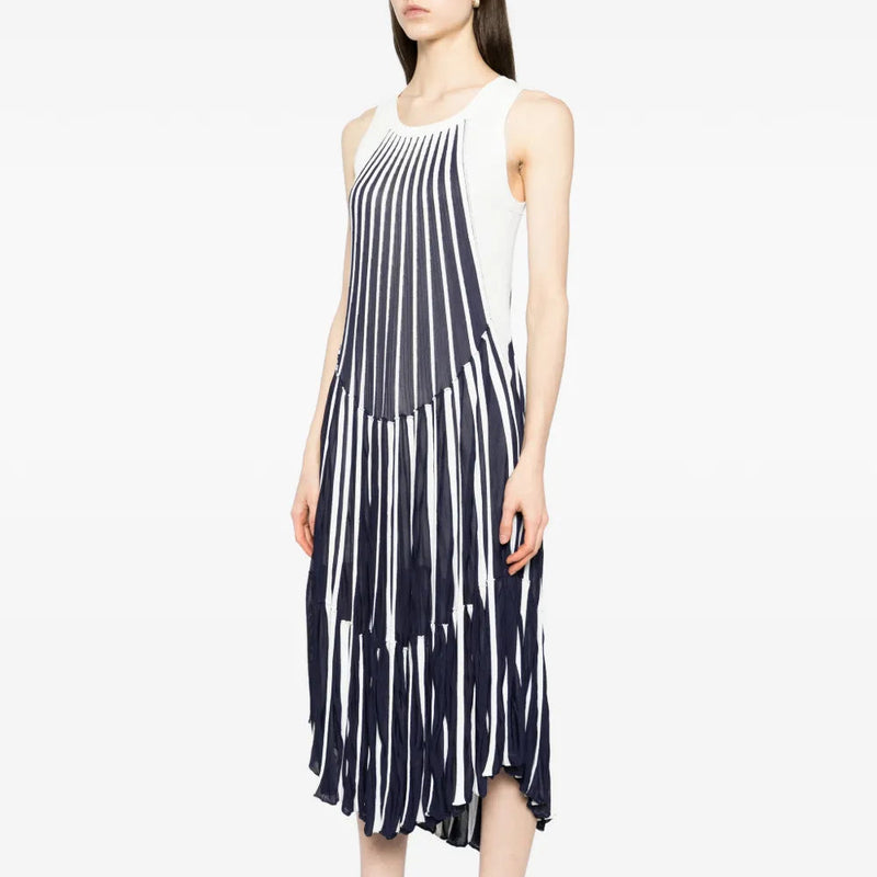 Side view of a Chloé blue and white pleated striped dress on a model, showcasing the elegant, flowing design and classic pattern.
