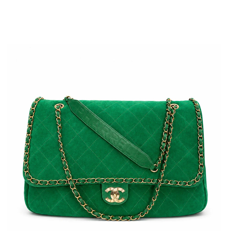 A green quilted suede shoulder bag with a silver-tone chain strap, shown from the back on a white background.