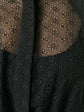 Black sheer broderie blouse by Alaïa featuring delicate floral embroidery and lightweight, semi-transparent fabric.