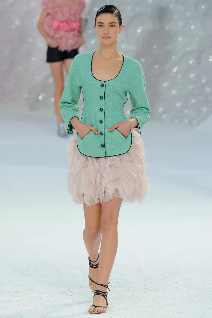 Mint green Chanel tweed jacket from spring 2012 with a belted design, classic blazer style, and textured fabric.