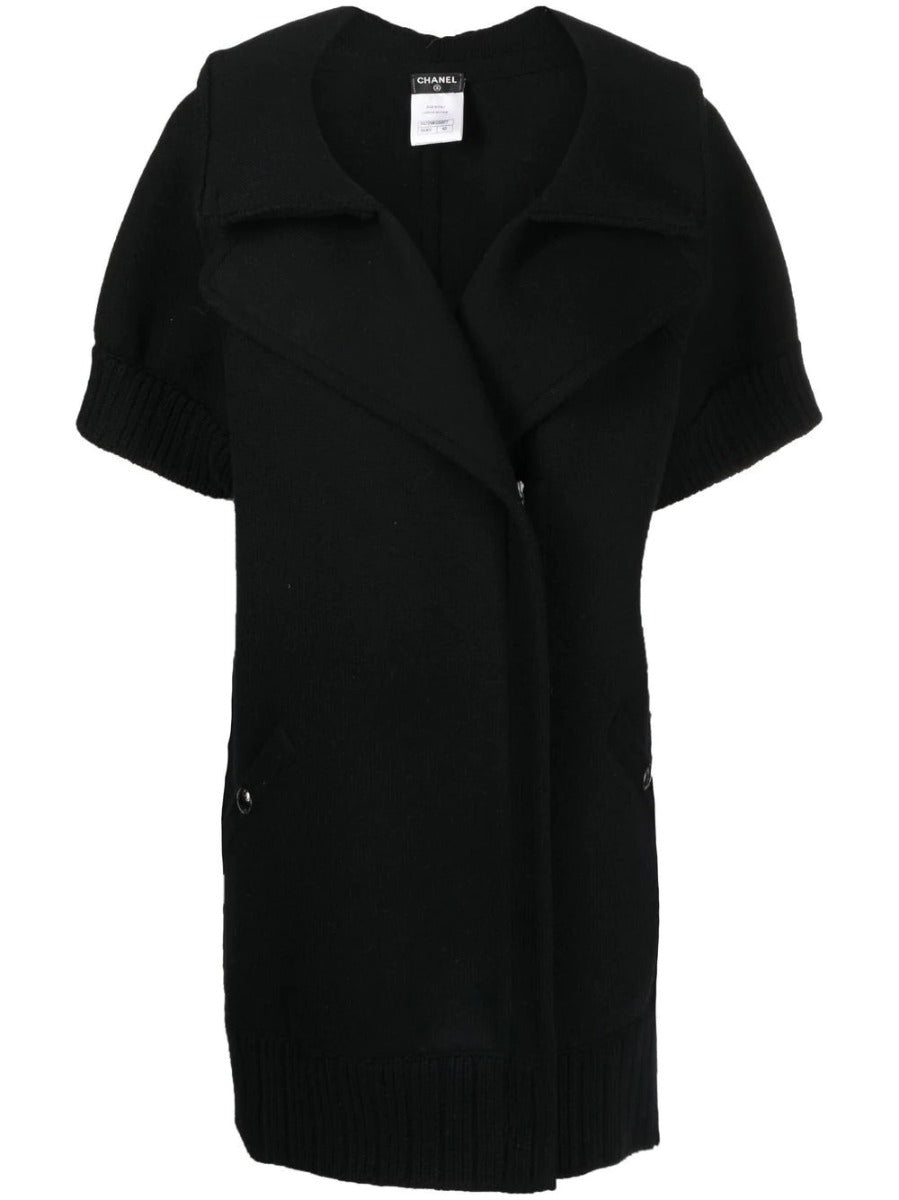 Black Chanel short-sleeved knit gilet, stylish blazer and jacket hybrid, featuring a sleek design and classic Chanel detailing.