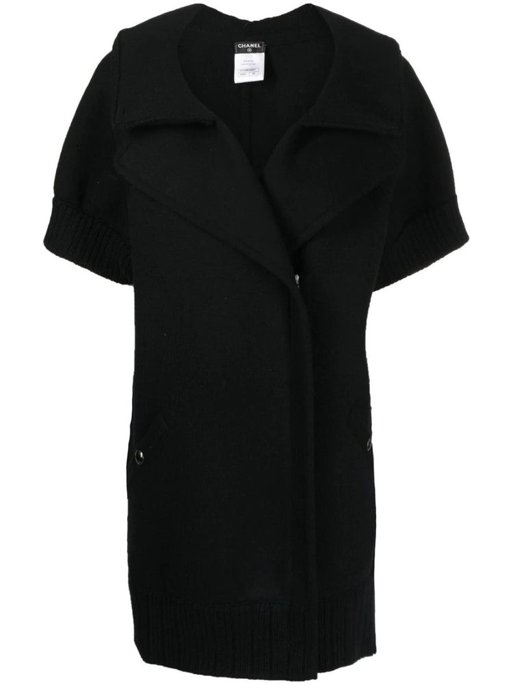 Black Chanel short-sleeved knit gilet, stylish blazer and jacket hybrid, featuring a sleek design and classic Chanel detailing.