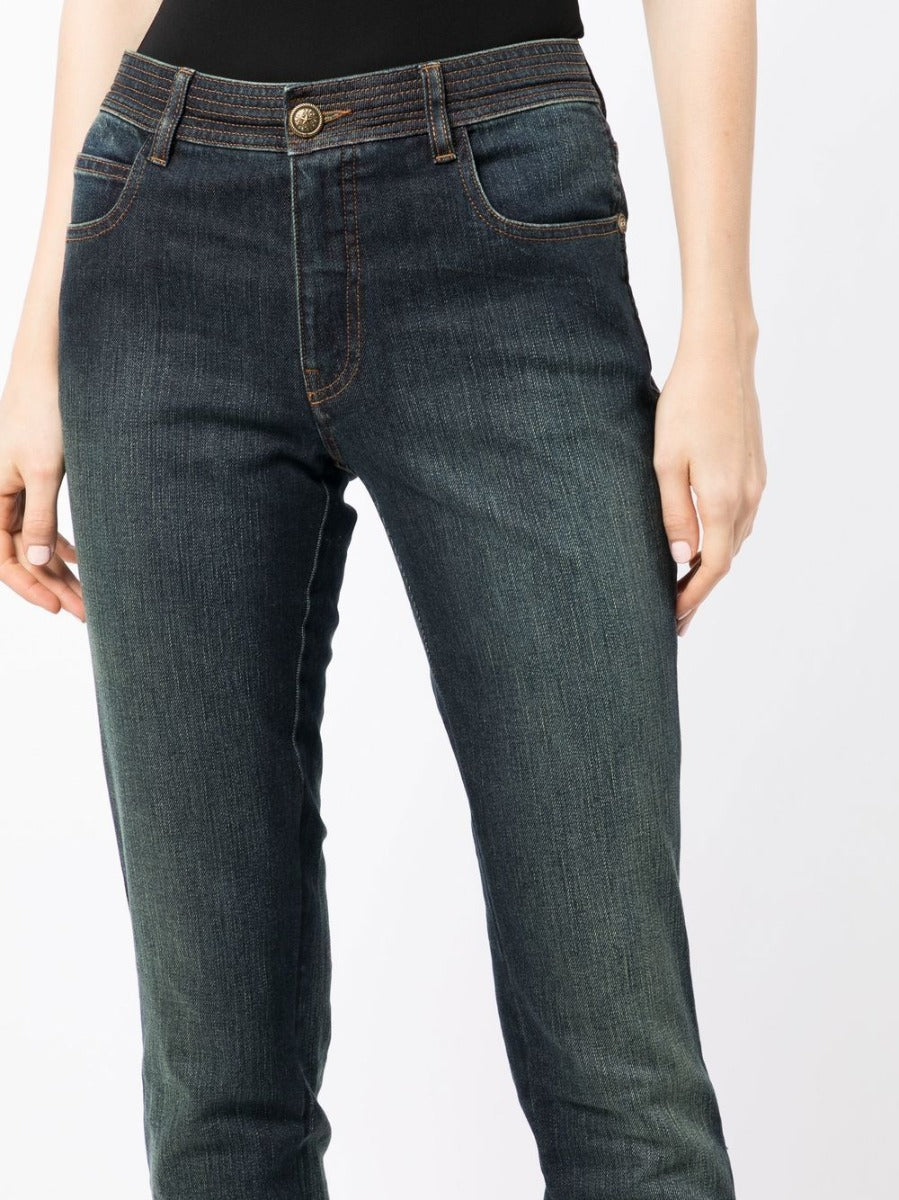 Chanel stonewashed skinny jeans trousers with a fitted design, detailed close-up of fabric texture and stitching.