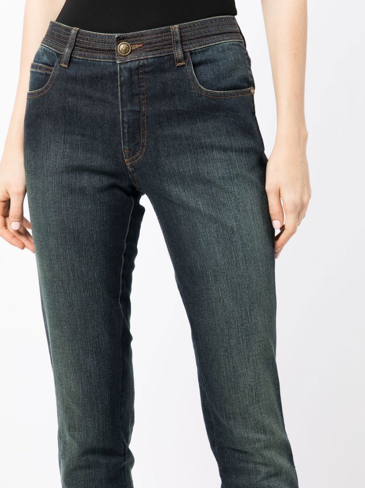 Chanel stonewashed skinny jeans trousers with a fitted design, detailed close-up of fabric texture and stitching.