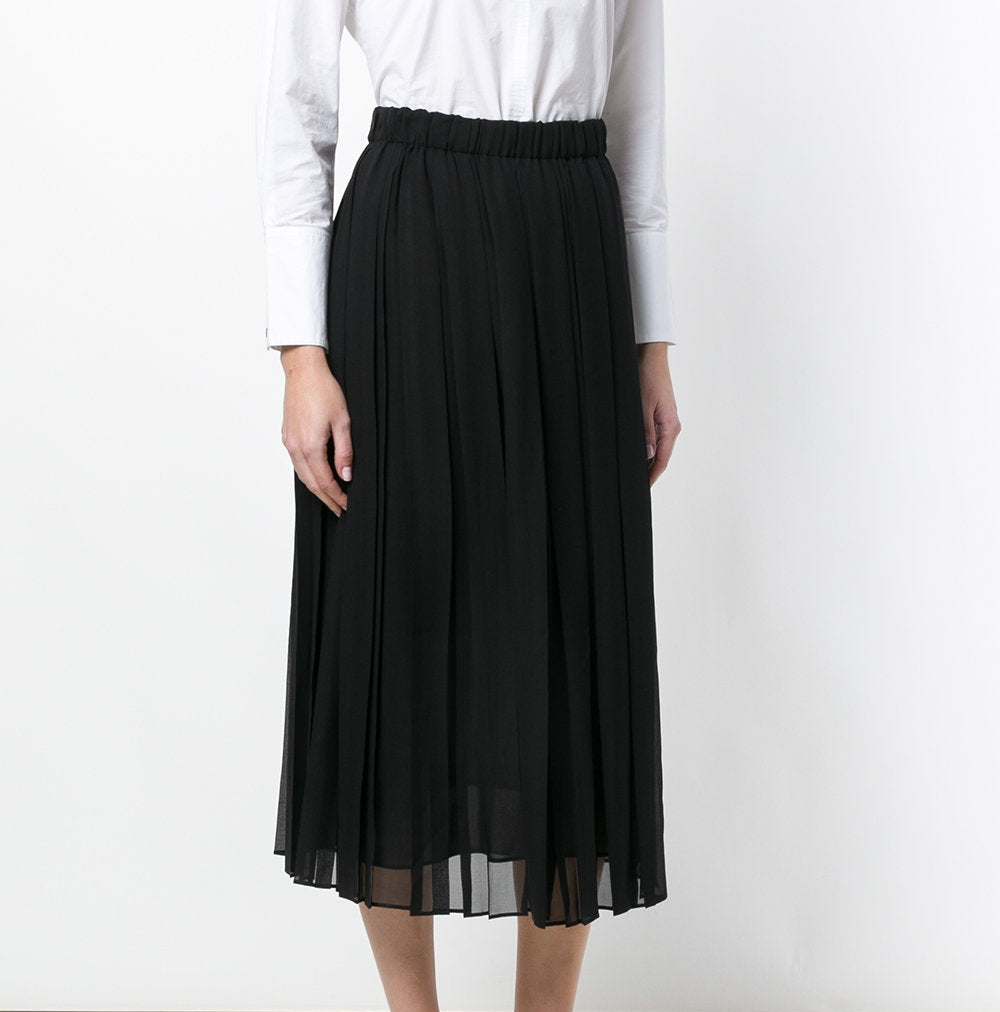 Black Gucci pleated skirt with a high waist and flowing pleats, styled as a chic fashion piece for women.