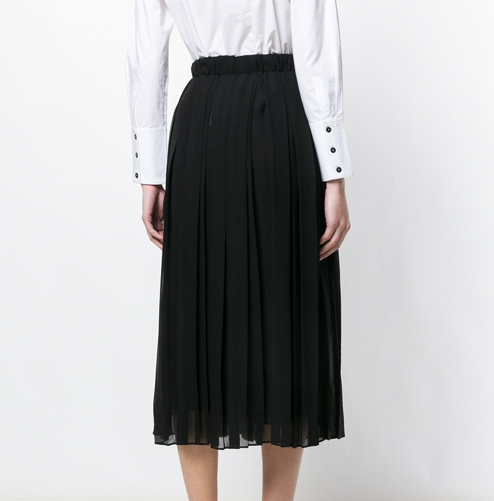 Black Gucci pleated skirt with sharp, evenly spaced pleats, stylish and elegant, shown on a model against a neutral background.