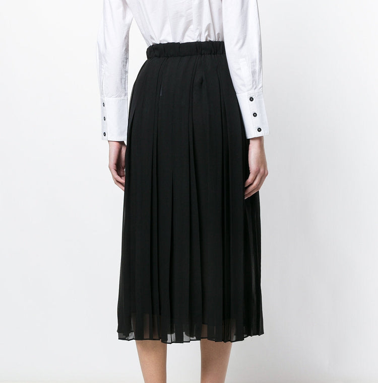 Black Gucci pleated skirt with sharp, evenly spaced pleats, stylish and elegant, shown on a model against a neutral background.
