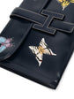 Hermès Butterfly Jige Elan PM clutch in black box leather with gold hardware, detailed with butterfly design and sleek finish.