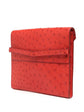 Hermès Red Ostrich Liddy Clutch Bag with envelope-style fold-over shape, vibrant red exotic leather, ostrich quill texture and minimalist structured silhouette.