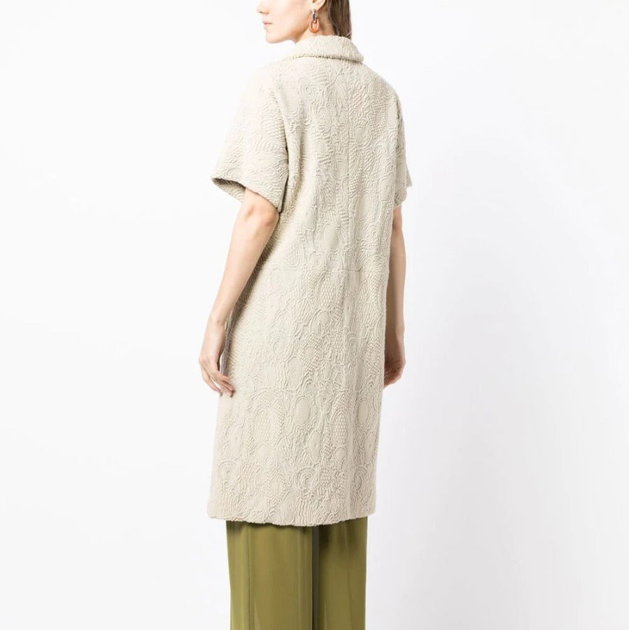 Bottega Veneta light beige short-sleeved jacquard coat with textured woven pattern, rounded collar, concealed fastening and flap pockets.