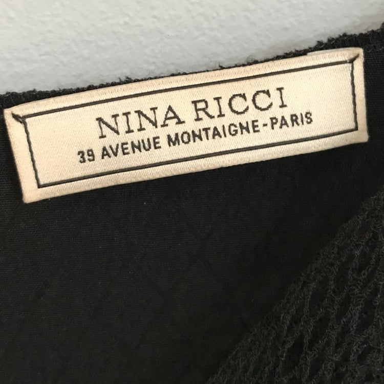 Nina Ricci black shift dress from Other Designers, shown on a hanger with label visible, featuring classic silhouette and sleek fabric.