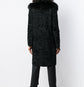 Black Prada Jacquard Astrakhan coat with textured woven fabric and classic tailored design, displayed on a hanger.