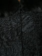 Prada black jacquard Astrakhan coat featuring textured fabric, tailored fit, and classic collar detail, displayed on a hanger.