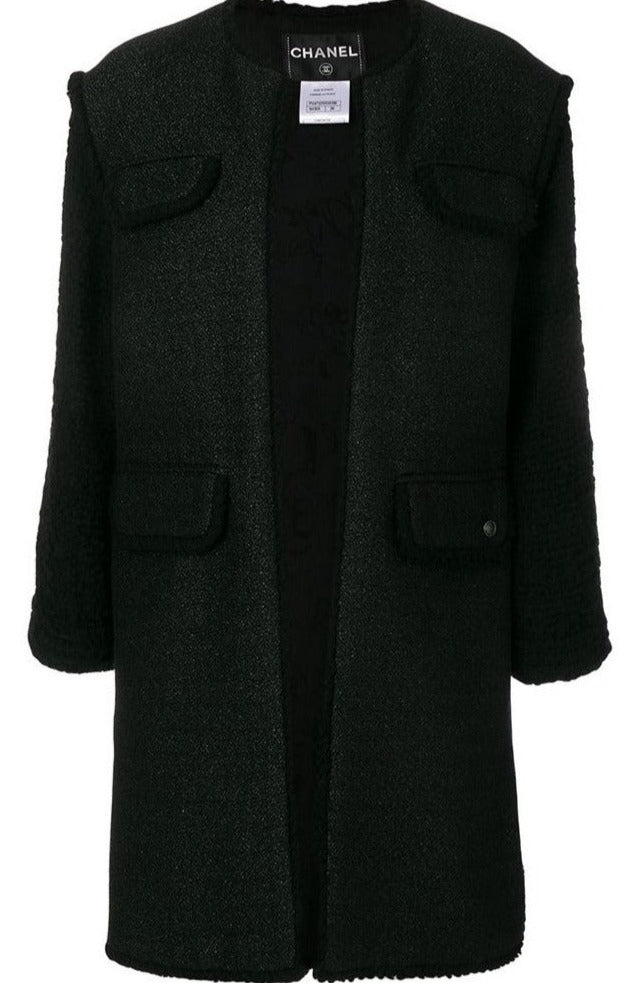 Chanel black tweed coat displayed on a hanger, showcasing classic textured fabric and tailored design.