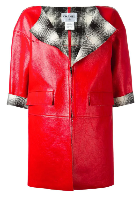 Chanel red leather coat hanging on a wooden hanger, showcasing its stylish design and vibrant color.